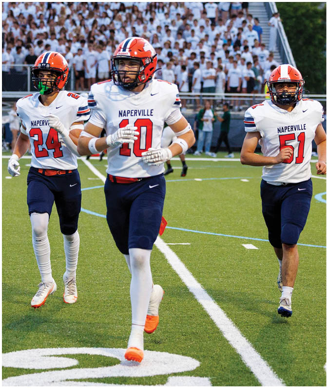A group of football players wearing black and white uniforms. Description generated by AI
