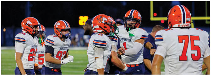 A group of football players on a field. Description generated by AI