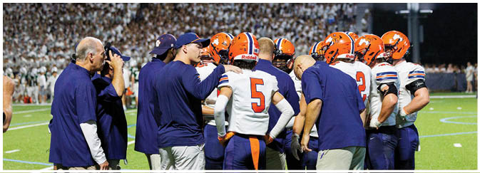A group of football players on a field. Description generated by AI