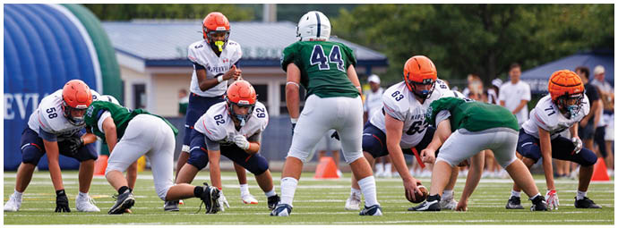 A football player wearing a blue and white uniform. Description generated by AI