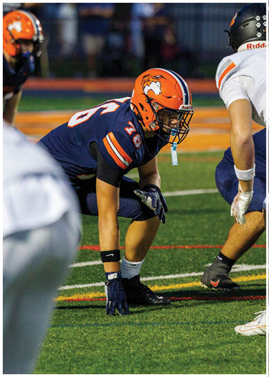 A football player wearing a blue jersey with the number 58 on it. Description generated by AI