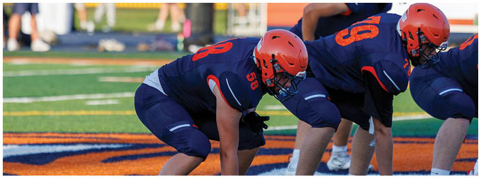 A football player wearing a blue and white uniform. Description generated by AI