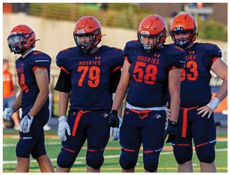 A group of football players on a field. Description generated by AI