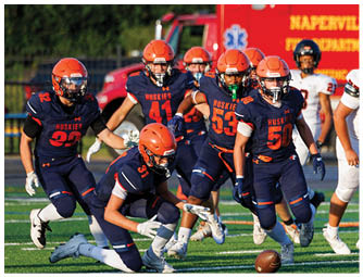 A group of football players on a field. Description generated by AI