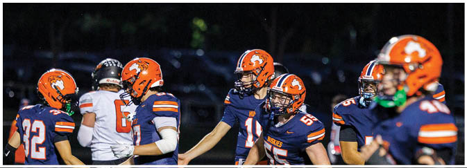 A group of football players on a field. Description generated by AI