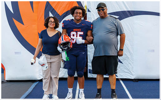A group of football players wearing black and white uniforms. Description generated by AI