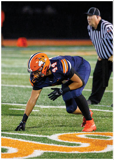 A football player wearing a blue jersey with the number 58 on it. Description generated by AI