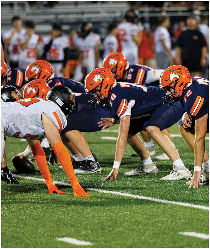 A group of football players wearing black and white uniforms. Description generated by AI