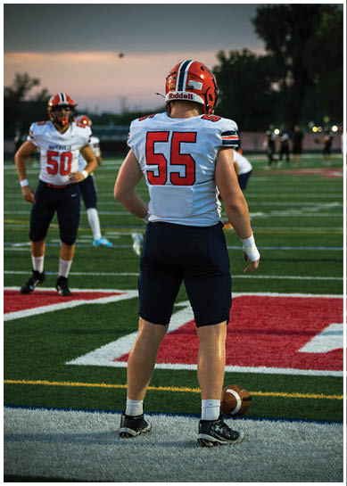 A football player wearing a blue jersey with the number 58 on it. Description generated by AI