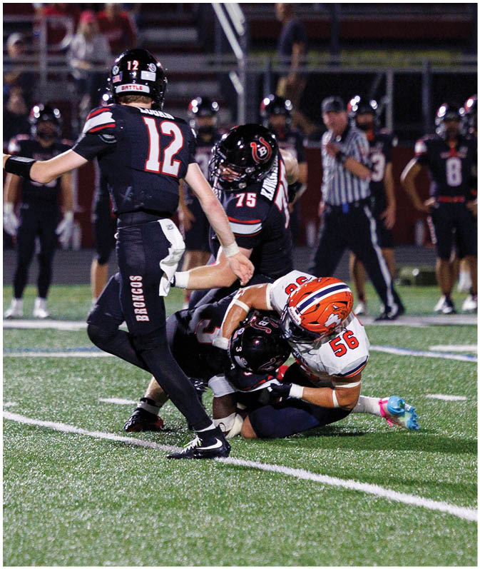 A group of football players wearing black and white uniforms. Description generated by AI