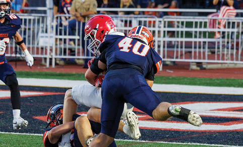 Two men wearing football uniforms are hugging each other on a field. AI generated content
