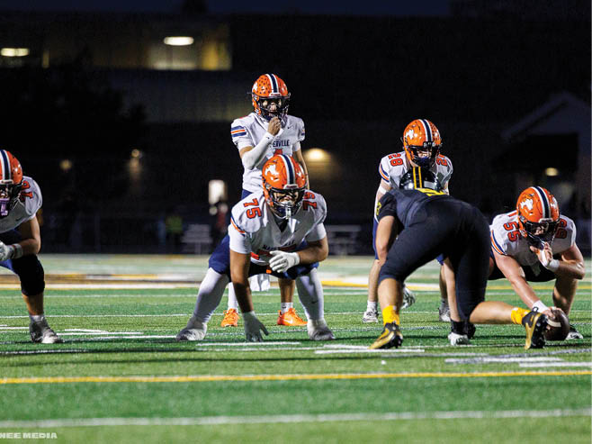 A group of football players in black and white uniforms are on the field. AI generated content