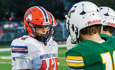 Two men wearing football uniforms are hugging each other on a field. AI generated content