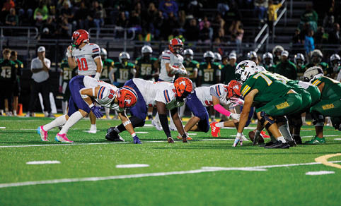 Two men wearing football uniforms are hugging each other on a field. AI generated content