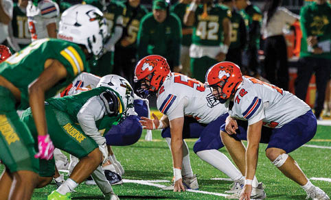 Two men wearing football uniforms are hugging each other on a field. AI generated content
