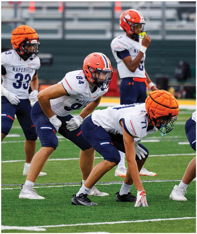 A group of football players wearing black and white uniforms. Description generated by AI
