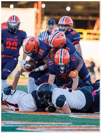 A group of football players on a field. Description generated by AI