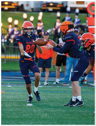 A group of football players on a field. Description generated by AI