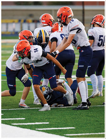 A group of football players on a field. Description generated by AI