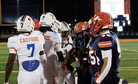 Two men wearing football uniforms are hugging each other on a field. AI generated content