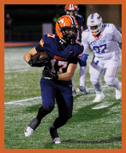 A football player in a white uniform is running with a football in his hand. AI generated content