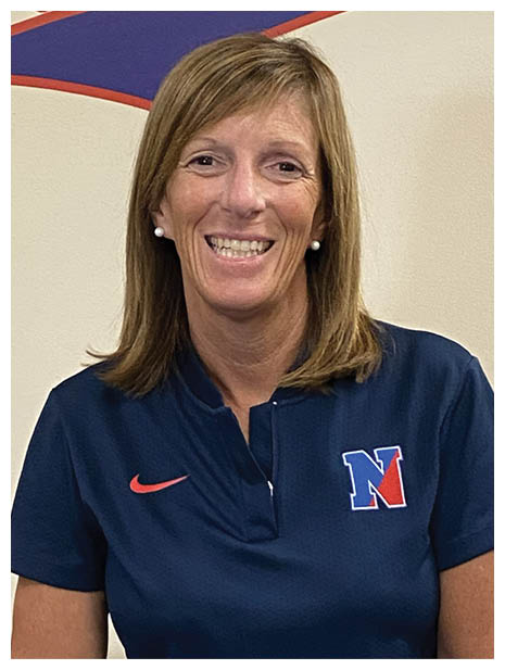 A person with shoulder-length straight hair is smiling and wearing a navy blue Nike shirt with a red and blue “N" logo. Description generated by AI