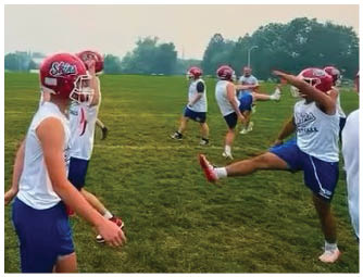 A group of football players on a field. Description generated by AI