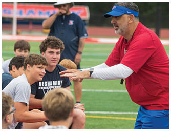 A group of football players on a field. Description generated by AI