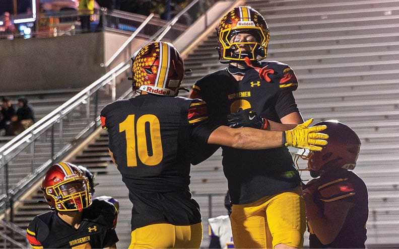 A group of football players celebrating on the field. Description generated by AI