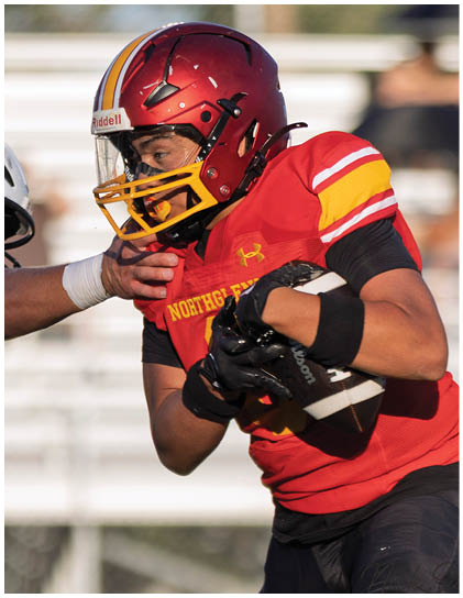 A football player in a red and yellow jersey is running with the ball. Description generated by AI
