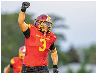 A football player wearing a red and yellow jersey with the number 3 on it. Description generated by AI