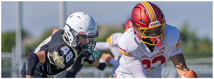 A football player in a white jersey with the number 22 on it is about to catch a football. Description generated by AI