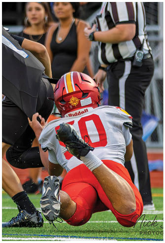 A football player is sliding on the ground. Description generated by AI