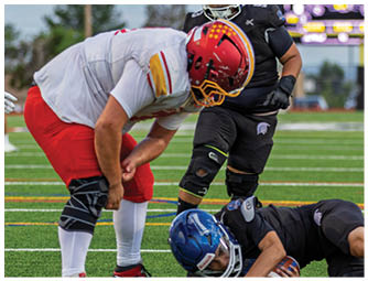 A football player is lying on the ground with his helmet off. Description generated by AI