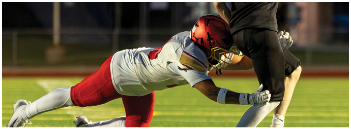 A football player in a white jersey is sliding on the ground. Description generated by AI