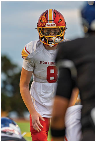 A football player wearing a white jersey with the number 8 on it. Description generated by AI