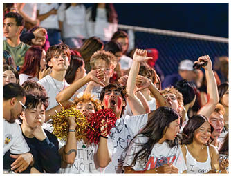 A group of people are sitting in the bleachers. Description generated by AI