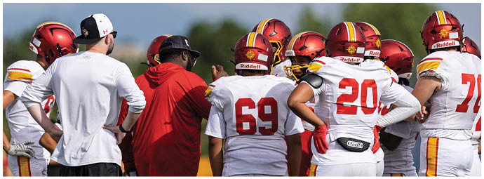 A group of football players wearing red and white uniforms. Description generated by AI