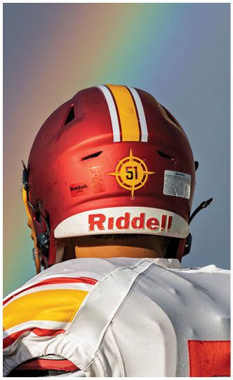 A football player wearing a white and red helmet. Description generated by AI