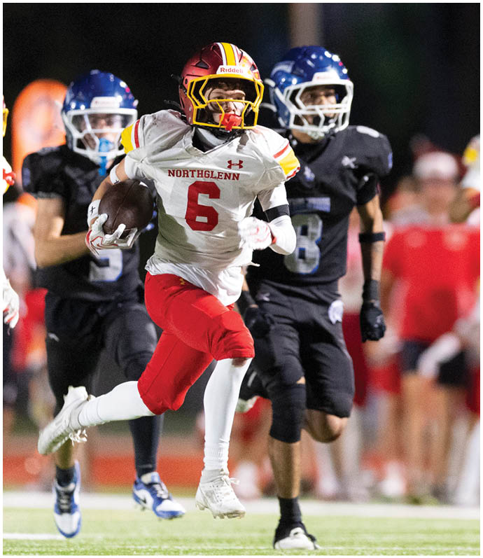 A football player running with the ball. Description generated by AI
