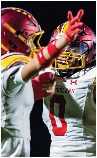 Two football players wearing red and white uniforms. Description generated by AI