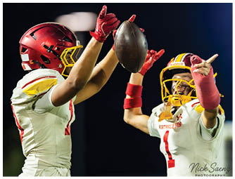 Two football players celebrating with a football. Description generated by AI