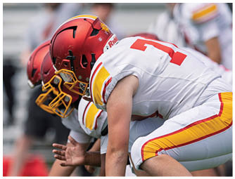 Two football players kneeling on the field. Description generated by AI