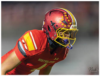 A football player wearing a red and yellow jersey with the number 7 on it. Description generated by AI