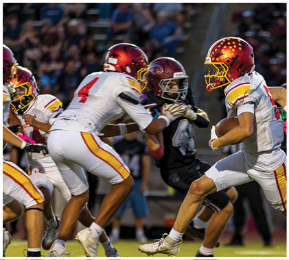 A group of football players running on a field. Description generated by AI