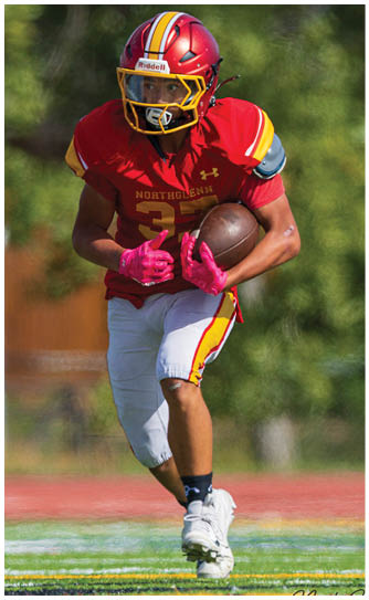 A football player wearing a red and yellow jersey with the number 3 on it. Description generated by AI