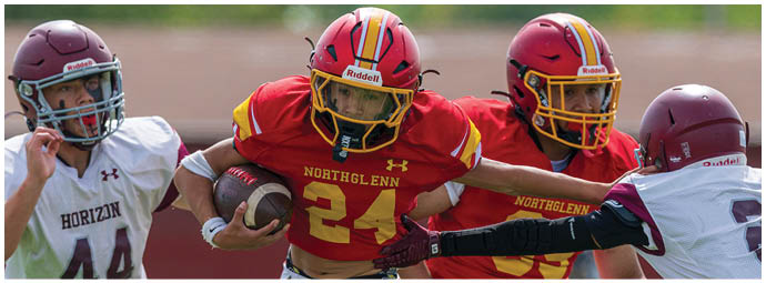 A football player wearing a red and yellow jersey. Description generated by AI