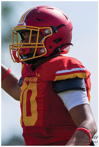A football player wearing a red and yellow jersey with the number 8 on it. Description generated by AI