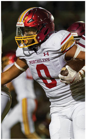 A football player wearing a red and white jersey with the number 8 on it. Description generated by AI
