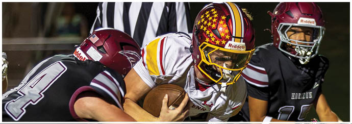 A football player in a black jersey is tackling another player. Description generated by AI